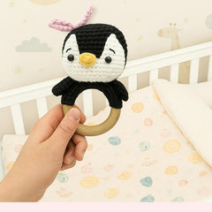 Handmade Penguin Crochet Rattle Resting on a Soft Surface