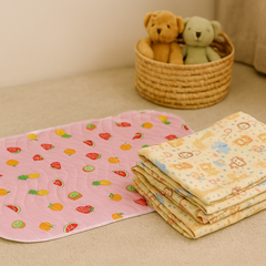 Fruit print baby dry sheet and animal print crib sheet shown together