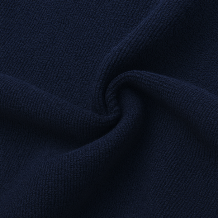 A close-up of dark navy blue ribbed knit fabric, showing the texture and a soft swirl in the material.