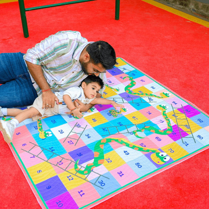 Children playing snakes and ladders on the Happy Matty picnic mat