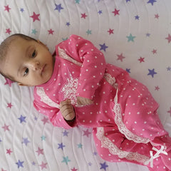 Baby lying on a Happy Matty star print bed protector mat
