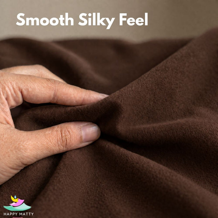 A close-up of a hand stretching and folding a smooth, dark brown fabric, with the text 'Smooth Silky Feel' at the top and a 'Happy Matty' logo in the bottom-left corner.