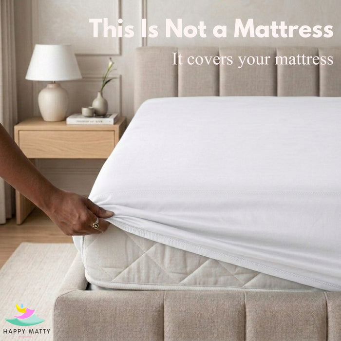 A white fitted sheet or mattress cover is being pulled taut over a mattress in a bed, with text reading 'This Is Not a Mattress It covers your mattress' and a Happy Matty logo in the corner.