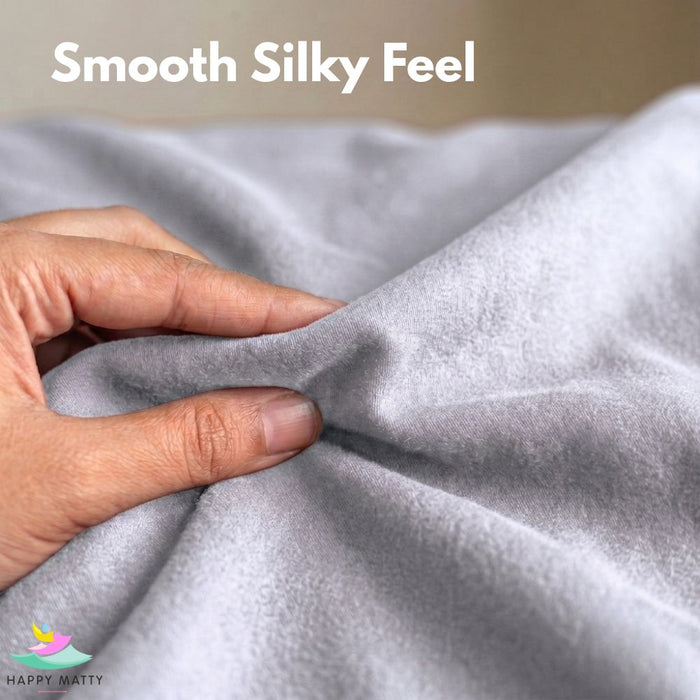 A close-up of a hand pulling and stretching a light gray plush fabric, with the text 'Smooth Silky Feel' at the top and a 'Happy Matty' logo in the bottom-left corner.